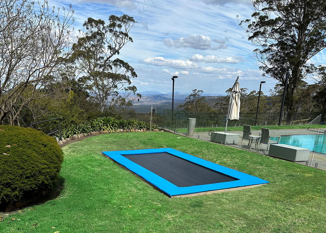 Inground trampoline in backyard with pool and view of valley